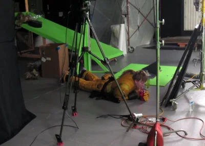 An actor lying on the ground, partially out of costume, drinking water.