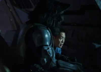 A man giving some direction to an actor in a wolf humanoid costume, between takes.